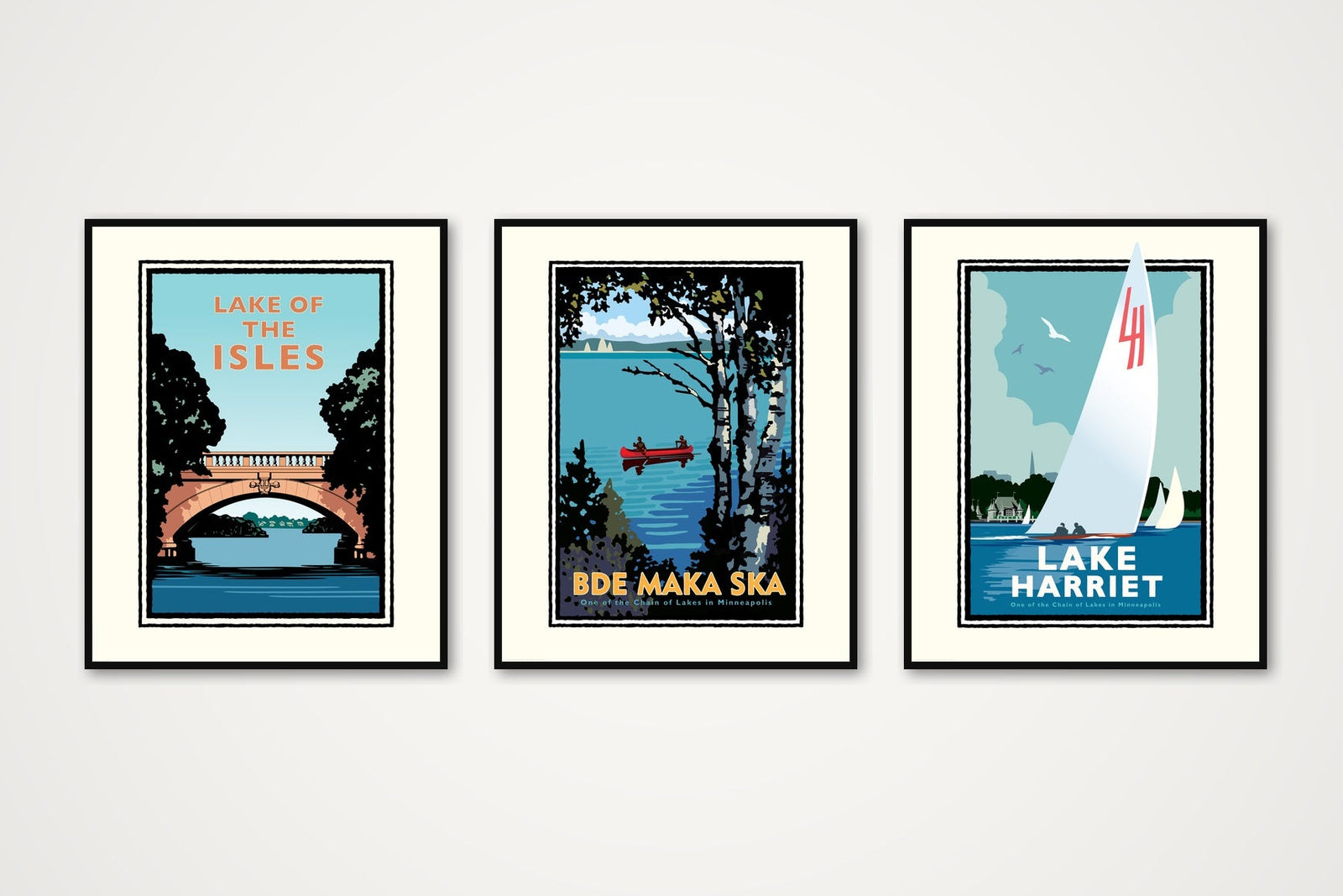 Three framed prints of scenic locations on a white wall