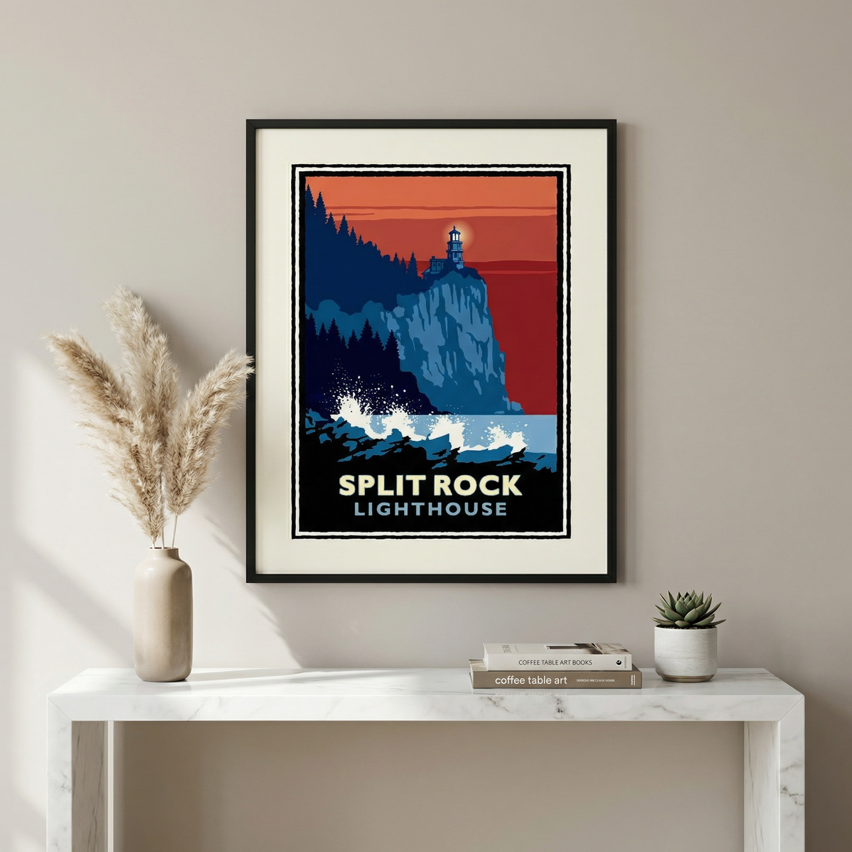 a framed poster of Split Rock Lighthouse, a lighthouse located in Maine, USA. The poster is hanging on a wall above a white table with a plant and a book on it.